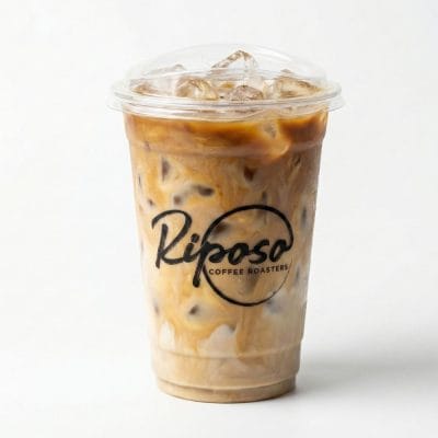 Clear plastic iced coffee cup with Riposo Coffee Roasters logo, custom printed cold cup for cafe beverages