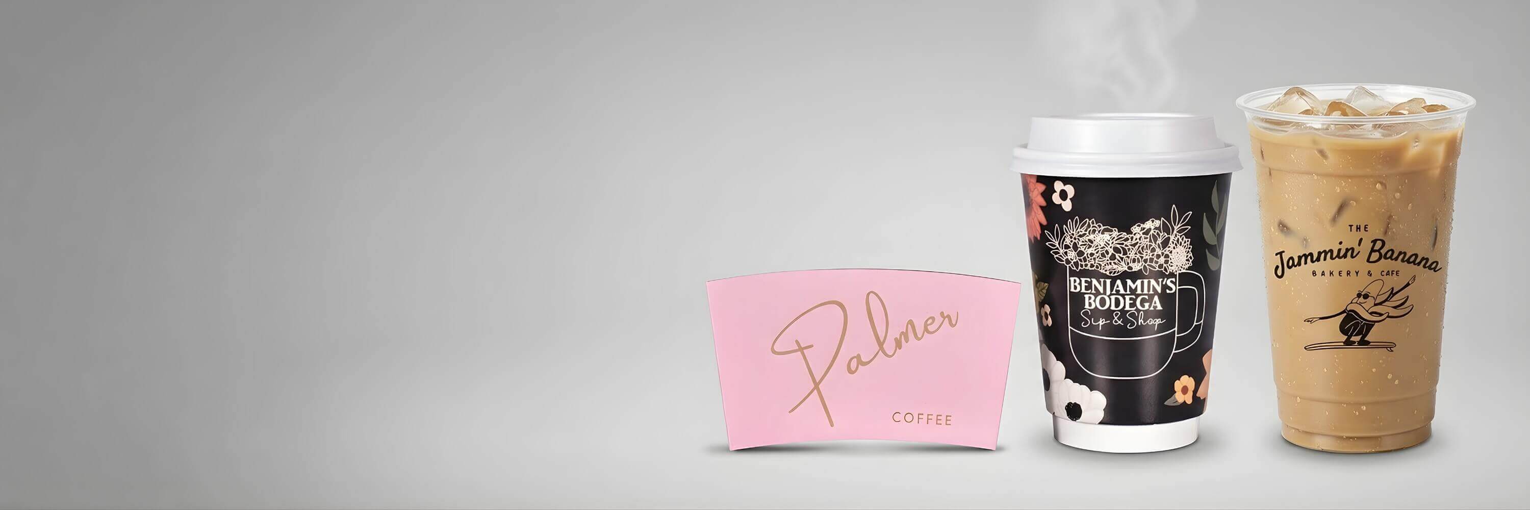 Branded pink coffee sleeve, floral custom paper hot cup, and logo-printed clear plastic iced coffee cup.