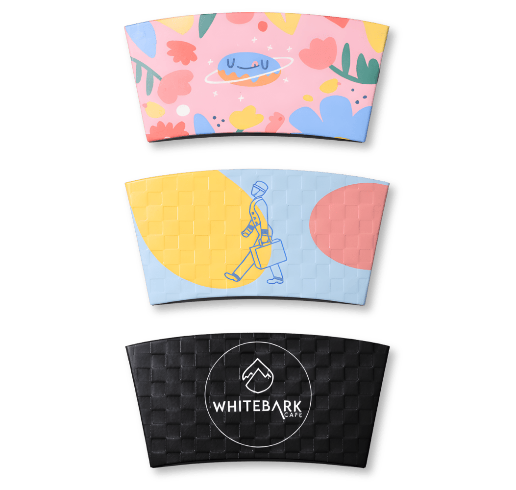Three custom-printed coffee sleeves showing colorful floral patterns, modern illustrations, and woven textures.