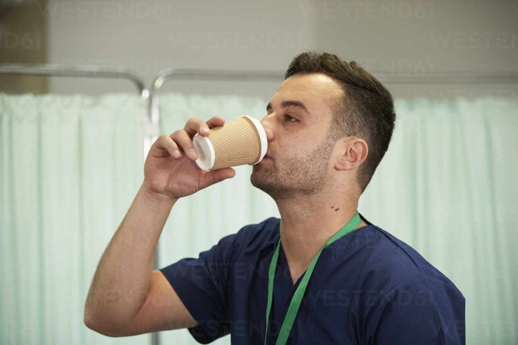 Man drinking from disposable paper cup